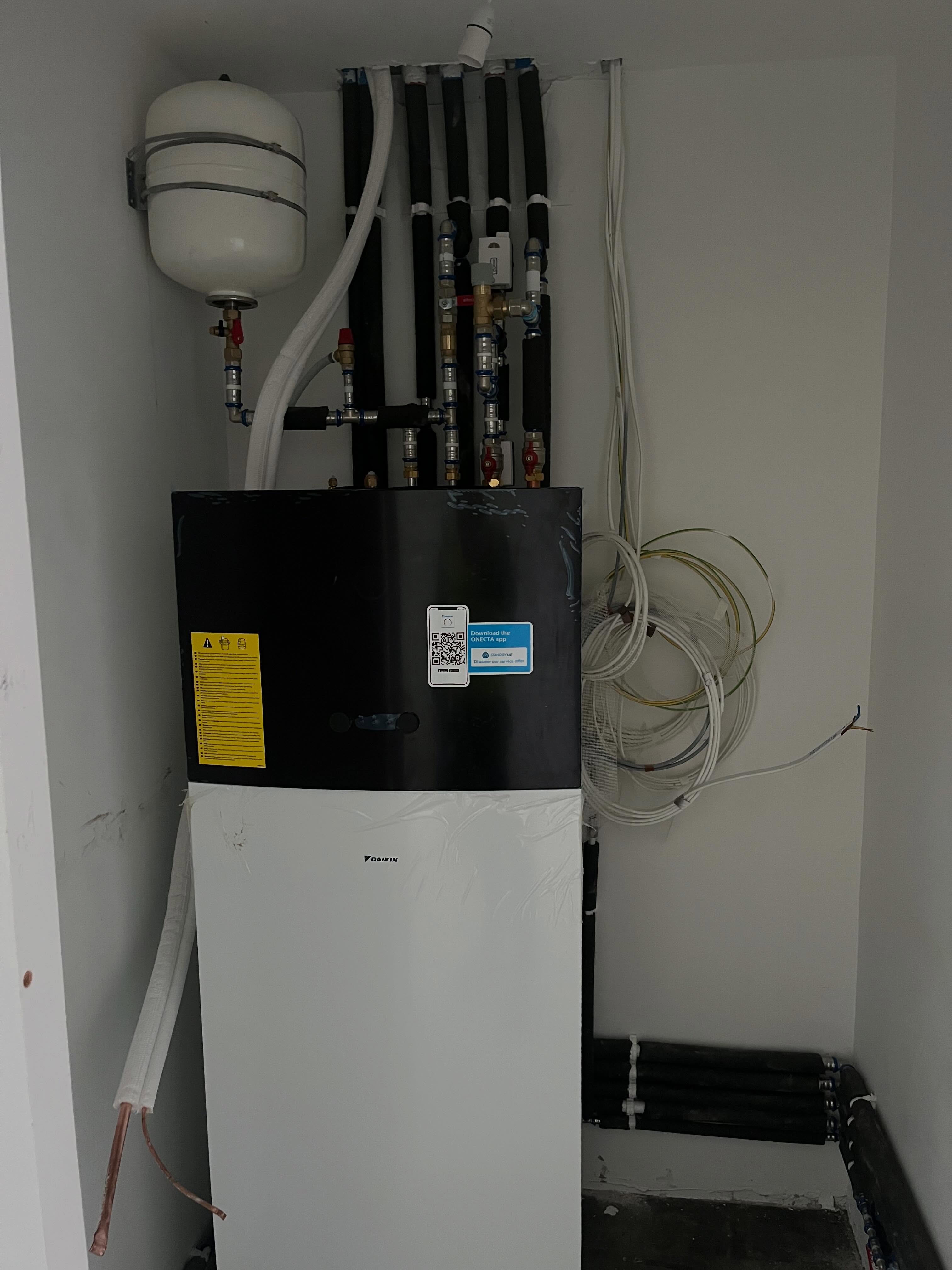 Heat pump indoor unit and hot water cylinder with pipework and an expansion vessel